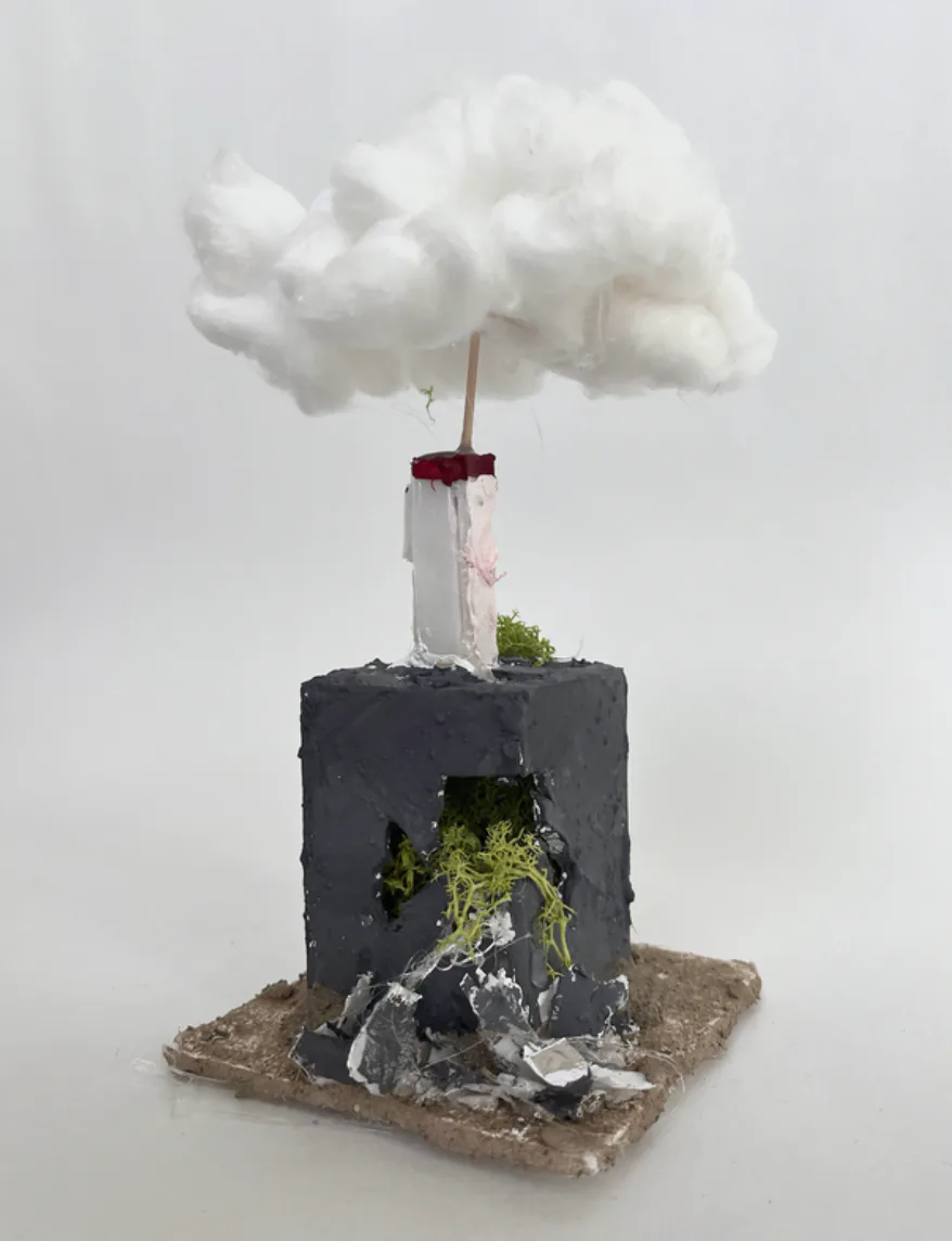 A foam core architectural model of a single tower with a cotton plume rising above it.